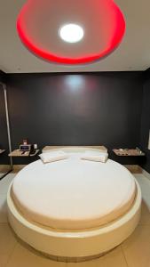 a large white bed in a room with a red ceiling at Luxu's Motel in Tucano