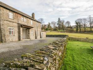an old stone wall next to a brick building at Crummock at the Graythwaite Estate in Sawrey