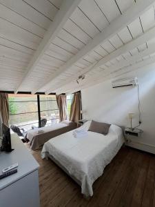 a bedroom with a bed and a desk with a television at La Huella in Chascomús