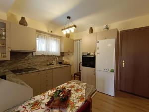 a kitchen with a bed and a white refrigerator at Νύμφη Ηχώ, Θέα στα βουνά κάτω από το Ρολόι in Dimitsana