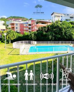 a view of a swimming pool from a balcony at Le Cosy 888 Studio Plage 1 min Piscine Restaurants Casino in Les Trois-Îlets