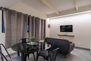 a dining room with a table and chairs and a tv at Cozy condo with rooftop in Roma Norte in Mexico City