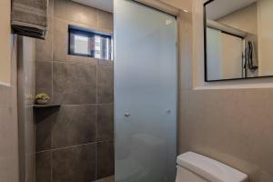 a bathroom with a toilet and a mirror at Cozy condo with rooftop in Roma Norte in Mexico City +12 photos