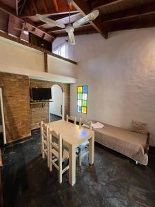 a room with a table and chairs and a bed at La Huella in Chascomús