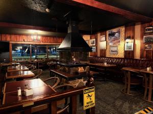 a restaurant with wooden tables and chairs in a room at Airport Chalet in Whitehorse
