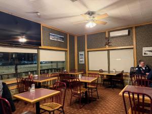 a dining room with tables and chairs and a ceiling fan at Airport Chalet in Whitehorse +12 photos