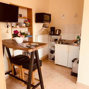 a kitchen with a table with a vase of flowers on it at Im Herzen von Chattengau in Gudensberg