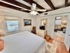 a bedroom with a white bed and a ceiling fan at Barefoot Beach Bungalow-Ground Level-3BR in St. George Island +44 photos