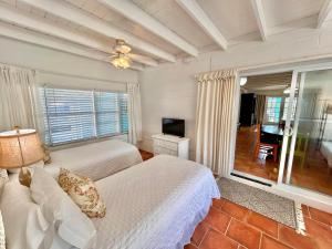a bedroom with two beds and a large window at Barefoot Beach Bungalow-Ground Level-3BR in St. George Island