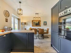 a kitchen with blue cabinets and a dining room at 3 Bed in Penrith oc-86724 in Hackthorpe