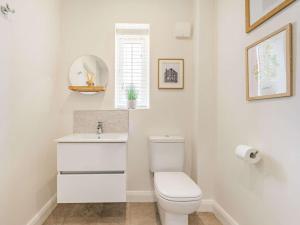 a white bathroom with a toilet and a sink at 3 Bed in Penrith oc-86724 in Hackthorpe +17 photos