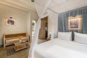 a bedroom with a white bed and a bench at Chaparrals Surf in Dickwella +65 photos