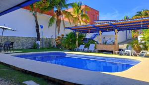 a swimming pool in front of a house at Hostal Villa Mayte Coronado in Las Lajas