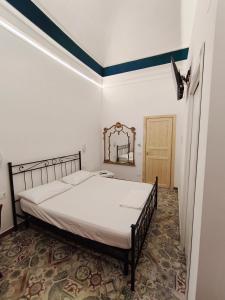 a bedroom with a bed and a mirror on the wall at casa Giuseppe in Catania