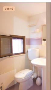 a bathroom with a white toilet and a sink at Casa Andrea in Cefalù