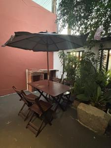 a wooden table and chairs with an umbrella at Casa Gabo in Serra +2 photos