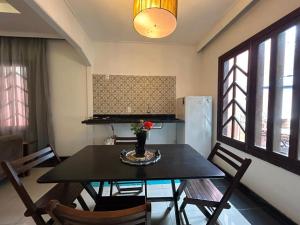 a dining room with a table and chairs and a kitchen at Casa Gabo in Serra