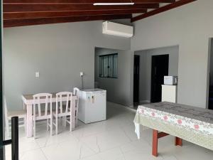 a living room with a table and chairs and a refrigerator at Casa com Spa aquecido em Itajuba in Barra Velha