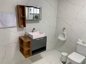 a bathroom with a sink and a toilet and a mirror at Casa com Spa aquecido em Itajuba in Barra Velha +14 photos