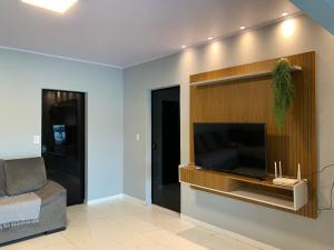 a living room with a flat screen tv on a wall at Casa com Spa aquecido em Itajuba in Barra Velha