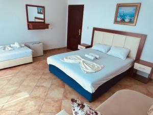a bedroom with two beds and a chair in it at Rozana Rooms in Ulcinj