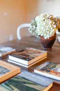 a table topped with books and a vase of flowers at Agriturismo La Frattina in Buonconvento