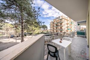 a balcony with a table and chairs and a building at Mare & Comfort - Box Auto - Balcone - Free Wifi in Borghetto Santo Spirito