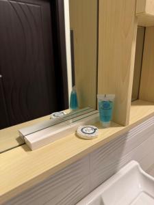 a bathroom counter with a mirror and a cup on it at اكنان للشقق المفروشة in Buraydah