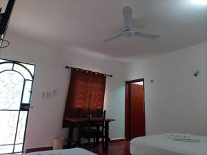ein Schlafzimmer mit Deckenventilator, Tisch und Fenster in der Unterkunft Hotel Casa Zued chichen itza in Pisté