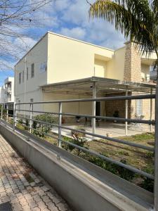 a white house with a fence in front of it at Afrodite Affittacamere in Metaponto