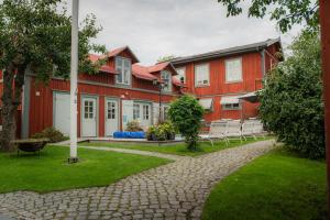 a row of red buildings with chairs in a yard at Tre Små Rum i Trosa in Trosa