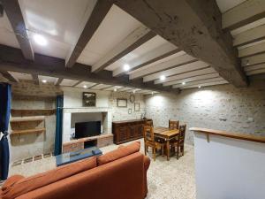 a living room with a couch and a table at Gîte de Marcoux, authentic and warme house in Saint-Laon