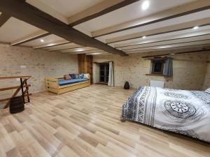 a bedroom with a bed and a wooden floor at Gîte de Marcoux, authentic and warme house in Saint-Laon