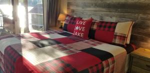 a bedroom with a bed with a plaid blanket and pillows at Olga's Bay Lakehouse in Minett