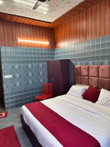 a bedroom with a large bed and a red chair at Bella Vista Hotel & Home Stay in Mussoorie