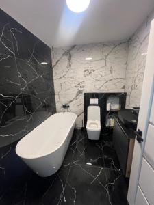 a black and white bathroom with a tub and a toilet at Casa Eva in Beclean