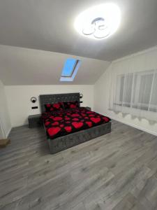 a bedroom with a bed with red roses on it at Casa Eva in Beclean