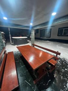 a large wooden table in a room with a bench at Casa Eva in Beclean +1 photo