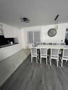 a white dining room with a table and chairs at Casa Eva in Beclean