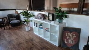 a living room with a white book shelf at Altmarkliebe Ferienhaus mit Garten für Familien & Hund in Gardelegen