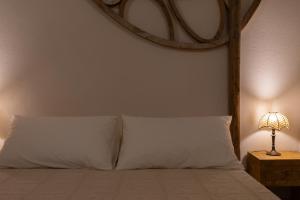 a bed with a white pillow and a lamp at La Ferrara Agriturismo in Vairano Patenora
