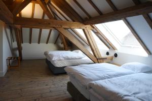 a room with two beds in a attic at Oud Tolkantoor in Alveringem +35 photos