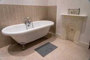 a white bath tub in a bathroom with a fireplace at The Red Door in Bangor