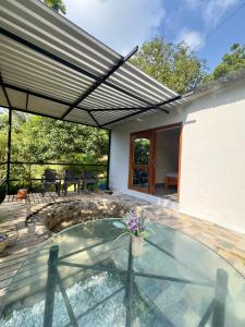 a patio with a glass table and an umbrella at Cabañas San Jose in Doradal +30 photos