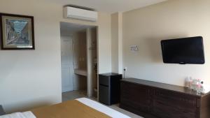 a bedroom with a bed and a tv on the wall at Hotel Del Viajero in Ciudad del Carmen