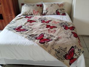 a bed with a bedspread with butterflies on it at Manor Rentals in Potchefstroom