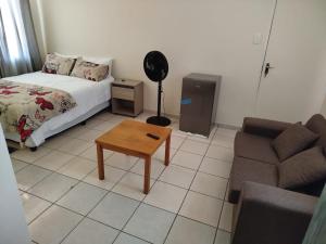 a bedroom with a bed and a table and a couch at Manor Rentals in Potchefstroom