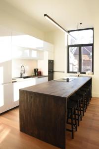 a kitchen with a large wooden island in the middle at Oud Tolkantoor in Alveringem