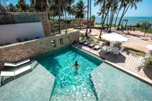 a person in the water in a swimming pool at Pedras Do Patacho Hotel Boutique Experience in Pôrto de Pedras