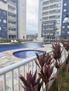 a balcony with a swimming pool and buildings at Apto frente o mar com 3 piscinas Wi-Fi gratuito aceito pet in Mongaguá